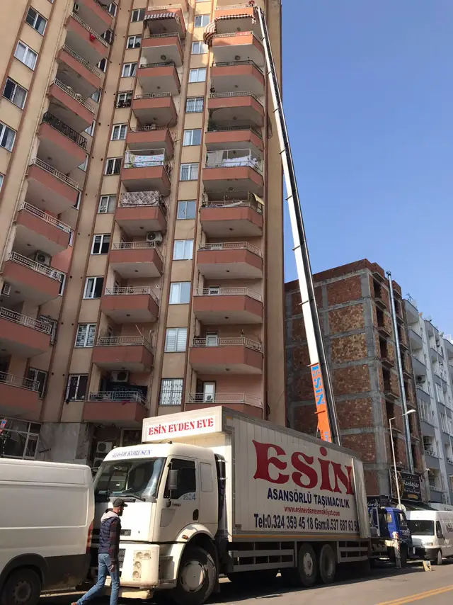 Esin Nakliyat asansörlü taşımacılık kamyonu ve mobil asansörü apartman önünde çalışırken